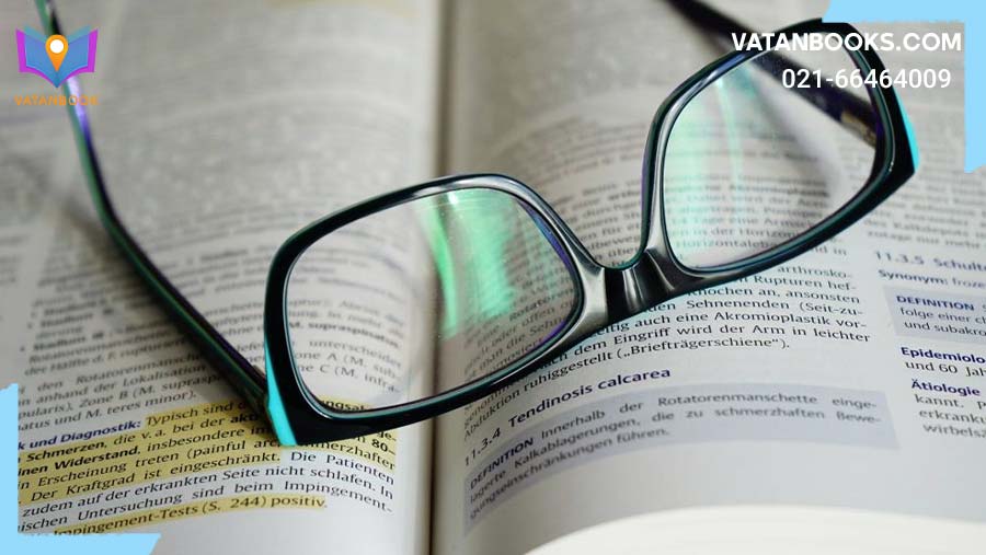 یک عینک مشکی که بر روی کتابی باز قرار گرفته